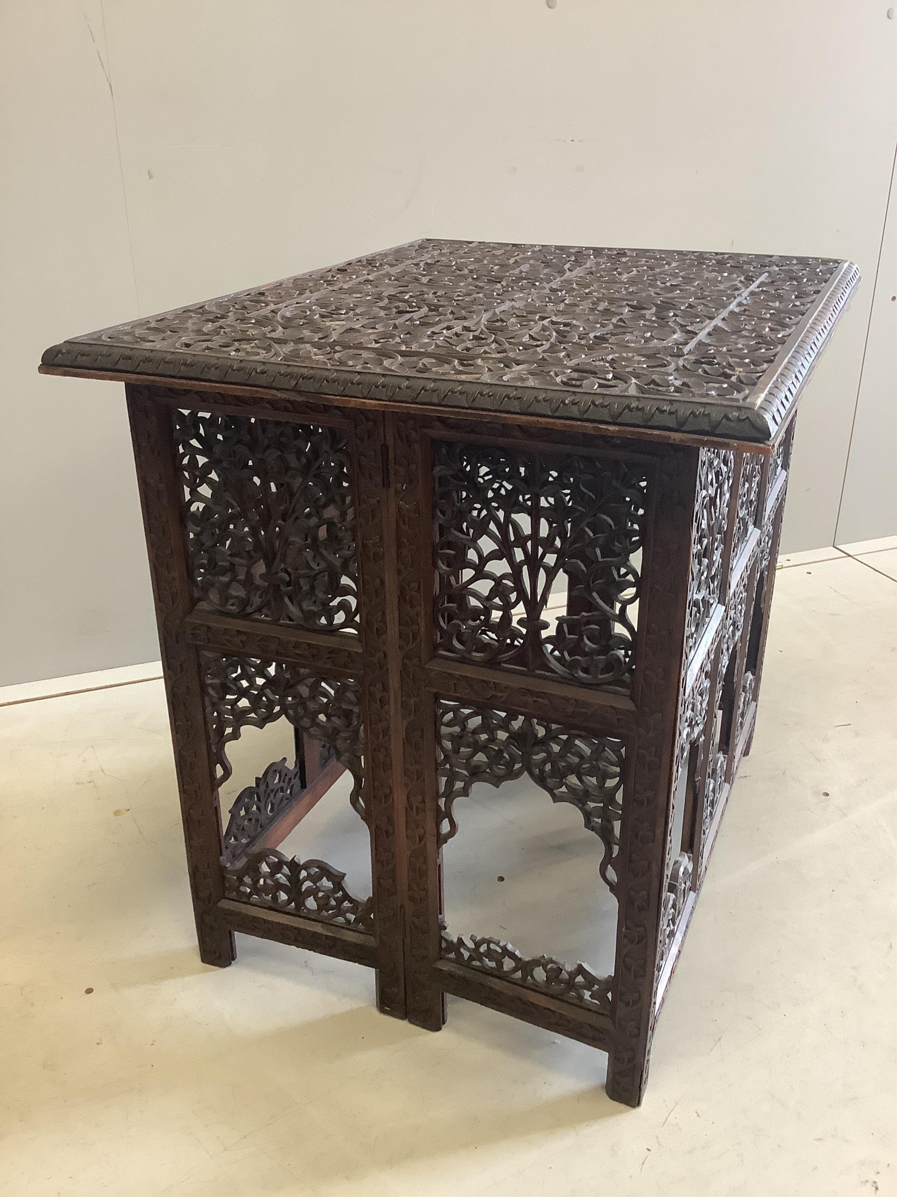 A late 19th century Burmese carved teak folding table, width 69cm, depth 55cm, height 163cm